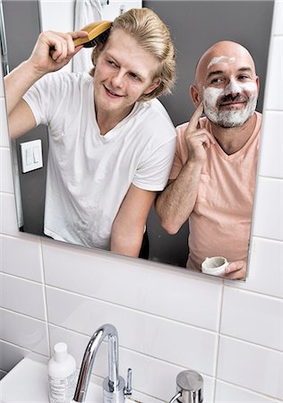 simsearch:649-08179955,k - Bathroom mirror image of male couple shaving and brushing hair Fotografie stock - Premium Royalty-Free, Codice: 614-08329486