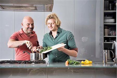 simsearch:614-08878073,k - Male couple preparing food together in kitchen Fotografie stock - Premium Royalty-Free, Codice: 614-08329495