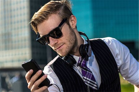 Young businessman in front of office reading smartphone texts, New York, USA Foto de stock - Sin royalties Premium, Código: 614-08329508