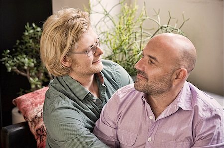 Romantic male couple looking at each other on sofa Stock Photo - Premium Royalty-Free, Code: 614-08329501