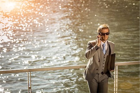 rail - High angle view of young businessman talking on smartphone on city waterfront Stock Photo - Premium Royalty-Free, Code: 614-08329511