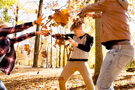 simsearch:614-06402622,k - Young woman and two teenage brothers throwing leaves at each other in autumn forest Stock Photo - Premium Royalty-Free, Code: 614-08329536
