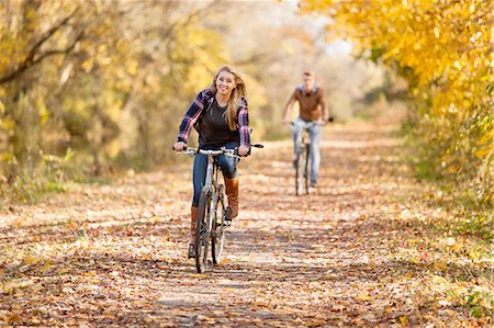 Teenage boy and adult sister cycling in autumn forest Stock Photo - Premium Royalty-Free, Code: 614-08329547