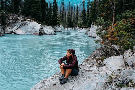 High angle view of mid adult woman sitting by waters edge looking away, Moraine lake, Banff National Park, Alberta Canada Stock Photo - Premium Royalty-Free, Code: 614-08383520