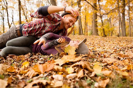 Young couple play fighting with autumn leaves in forest Stock Photo - Premium Royalty-Free, Code: 614-08383602