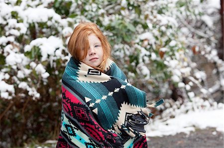 simsearch:614-09212275,k - Red haired girl in front of snow covered trees, wrapped in aztec pattern blanket looking at camera Photographie de stock - Premium Libres de Droits, Code: 614-08383652