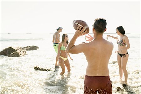 simsearch:614-08383690,k - Young adult friends playing American football in sea at Newport Beach, California, USA Foto de stock - Sin royalties Premium, Código: 614-08383664