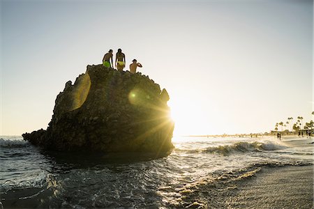 Silhouette of adult friends on rock formation at sunset, Newport Beach, California, USA Stock Photo - Premium Royalty-Free, Code: 614-08383689