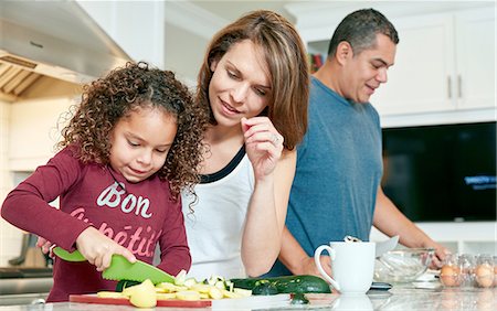 family mother father girl three hispanic - Mother helping daughter chop vegetables in kitchen Stock Photo - Premium Royalty-Free, Code: 614-08383711