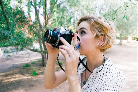 spiegelreflexkamera - Mid adult woman taking photographs in park Photographie de stock - Premium Libres de Droits, Code: 614-08392346