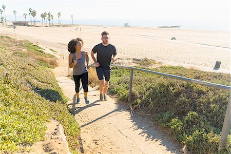 simsearch:614-08877438,k - Couple running along pathway by beach Stock Photo - Premium Royalty-Free, Code: 614-08392505