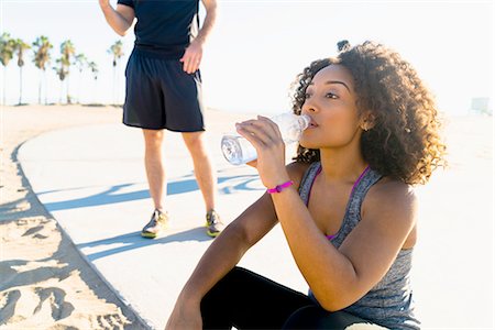 simsearch:614-08392515,k - Mid adult woman, by beach, drinking from water bottle Stock Photo - Premium Royalty-Free, Code: 614-08392510