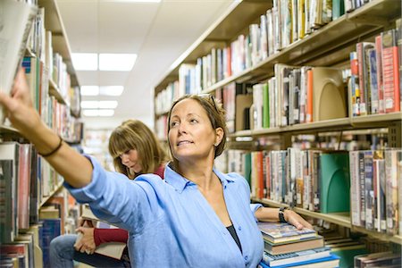 simsearch:614-08392557,k - Mature woman searching for books in library Stock Photo - Premium Royalty-Free, Code: 614-08392556