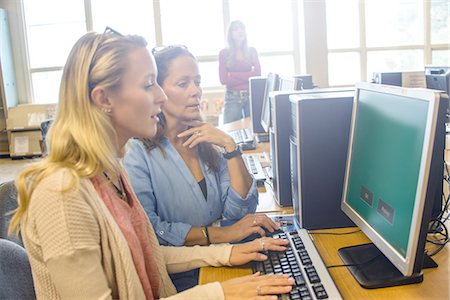 Two women searching computer data for books in library Photographie de stock - Premium Libres de Droits, Code: 614-08392557