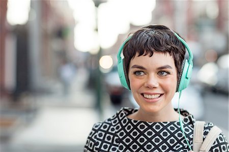 retro street - Mid adult woman, retro clothing, wearing headphones, outdoors Stock Photo - Premium Royalty-Free, Code: 614-08392632