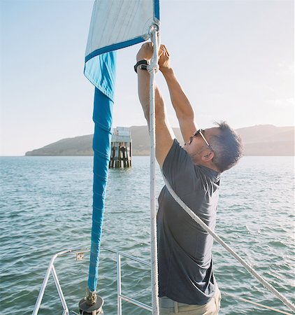 simsearch:614-08392689,k - Man tying up mainsail on sailboat, San Diego Bay, California, USA Stock Photo - Premium Royalty-Free, Code: 614-08392688