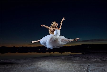 dancer jumping in the air - Young female ballet dancer leaping over Bonneville Salt Flats at night, Utah, USA Stock Photo - Premium Royalty-Free, Code: 614-08392718