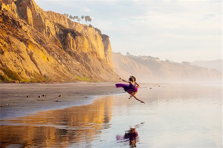 dancer isolated - Young female dancer, jumping, in mid air, over water at beach, San Diego, California, USA Stock Photo - Premium Royalty-Free, Code: 614-08487769