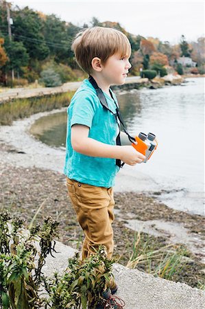 simsearch:614-08487786,k - Young boy standing beside lake, holding binoculars Stock Photo - Premium Royalty-Free, Code: 614-08487787