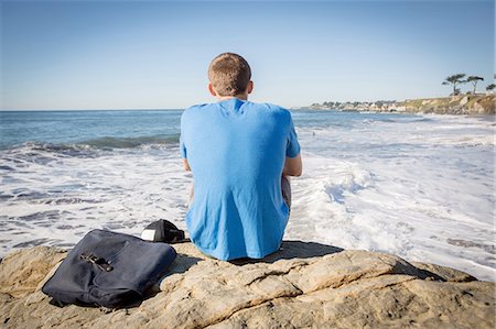 simsearch:614-06973887,k - Young man sitting by rock, looking out to sea, rear view Stock Photo - Premium Royalty-Free, Code: 614-08487833