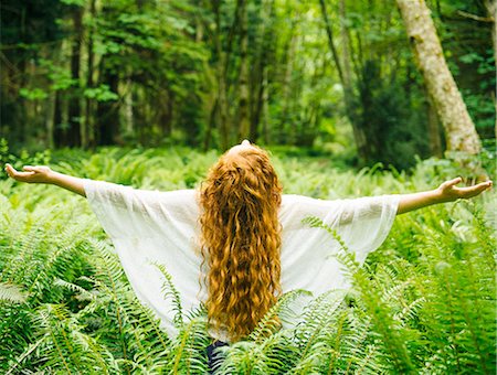 redhead female spiritual - Rear view of young woman with long red hair with arms open amongst  forest ferns Stock Photo - Premium Royalty-Free, Code: 614-08487971