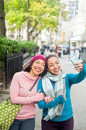 Twins walking and taking selfie with smartphone in park Stock Photo - Premium Royalty-Free, Code: 614-08487987