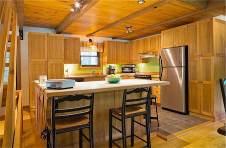 Wooden kitchen island with ceramic counter in Canadian cottage style log home Photographie de stock - Premium Libres de Droits, Code: 614-08488004