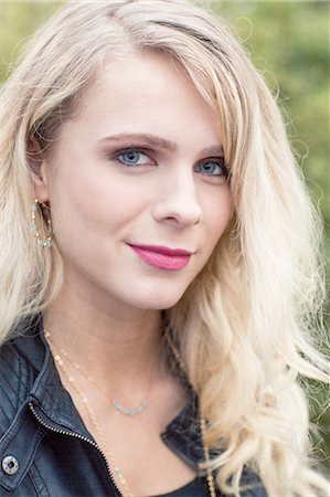 Close up portrait of young blonde haired woman wearing leather jacket looking at camera smiling Photographie de stock - Premium Libres de Droits, Code: 614-08488015