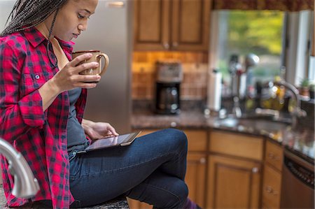 simsearch:614-08065899,k - Mid adult woman sitting in kitchen using digital tablet Stock Photo - Premium Royalty-Free, Code: 614-08488019