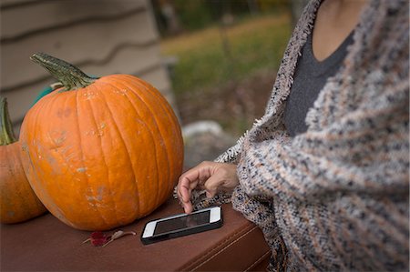 pumpkin home garden - Cropped shot of mid adult woman using smartphone touchscreen in garden Stock Photo - Premium Royalty-Free, Code: 614-08488028