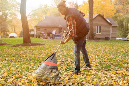 simsearch:614-08488024,k - Mid adult man raking in autumn leaves garden Photographie de stock - Premium Libres de Droits, Code: 614-08488029