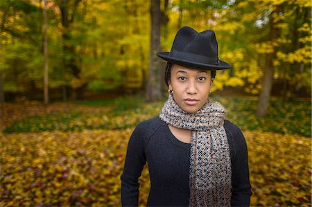 Portrait of mid adult woman wearing trilby and scarf in autumn forest Stock Photo - Premium Royalty-Free, Code: 614-08488023