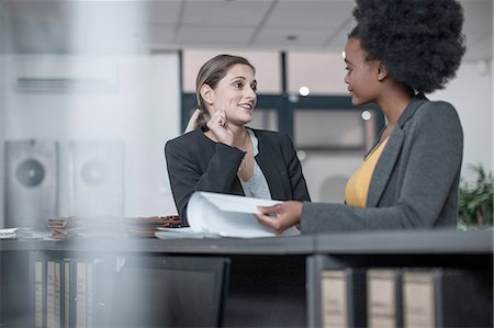 simsearch:614-08821459,k - Two young businesswomen talking at office reception Foto de stock - Royalty Free Premium, Número: 614-08488043