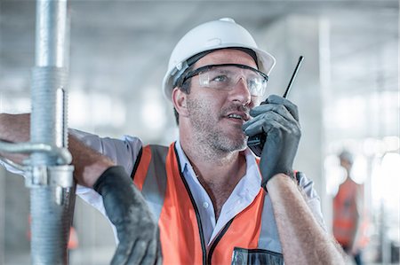 simsearch:614-06895837,k - Mid adult male site manager using walkie talkie on construction site Stock Photo - Premium Royalty-Free, Code: 614-08488088