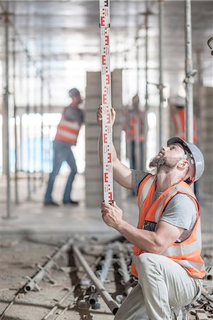 Young male builder measuring construction with ruler Stock Photo - Premium Royalty-Free, Code: 614-08488080