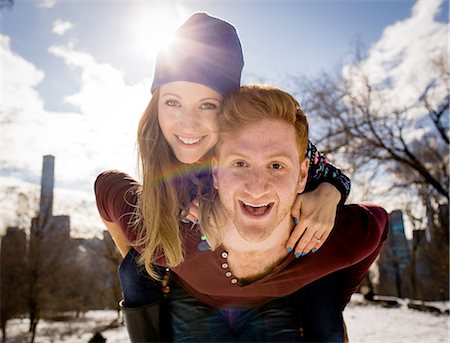 Portrait of young man giving girlfriend a piggy back in snowy Central Park, New York, USA Stock Photo - Premium Royalty-Free, Code: 614-08535574
