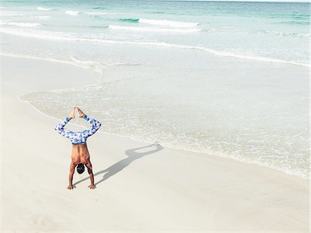 simsearch:614-06814385,k - Mature man doing handstand on beach, South Pointe Park, South Beach, Miami, Florida, USA Photographie de stock - Premium Libres de Droits, Code: 614-08535618