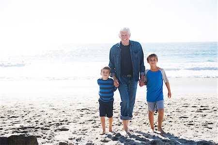 simsearch:614-07235020,k - Grandfather with two grandsons, walking on beach, smiling Fotografie stock - Premium Royalty-Free, Codice: 614-08535648