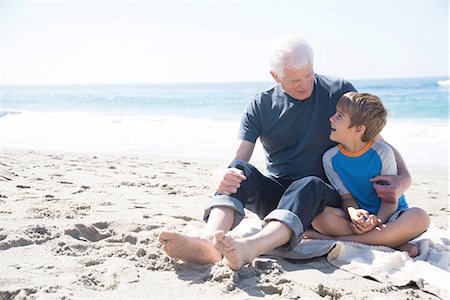 simsearch:614-07235015,k - Grandfather and grandson sitting on beach, smiling Fotografie stock - Premium Royalty-Free, Codice: 614-08535643