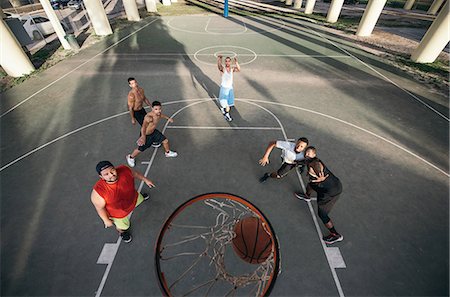 High angle view of men on basketball court watching basketball going through basketball hoop Stock Photo - Premium Royalty-Free, Code: 614-08535662