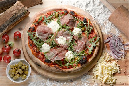 Overhead view of parma ham pizza with green olives Stockbilder - Premium RF Lizenzfrei, Bildnummer: 614-08535743