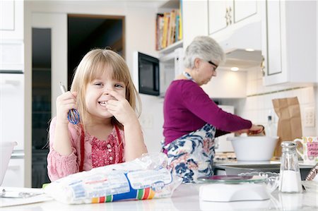 simsearch:614-08535822,k - Portrait of girl holding a whisk whilst cooking with grandmother Stock Photo - Premium Royalty-Free, Code: 614-08535813