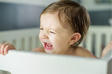 Head and shoulders of baby boy crying in crib Photographie de stock - Premium Libres de Droits, Code: 614-08535904