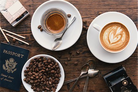 Overhead view of coffee's, coffee beans and American passport on coffee shop table Photographie de stock - Premium Libres de Droits, Code: 614-08535968