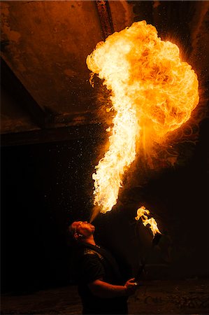 Man fire breathing in urban area Photographie de stock - Premium Libres de Droits, Code: 614-08535993