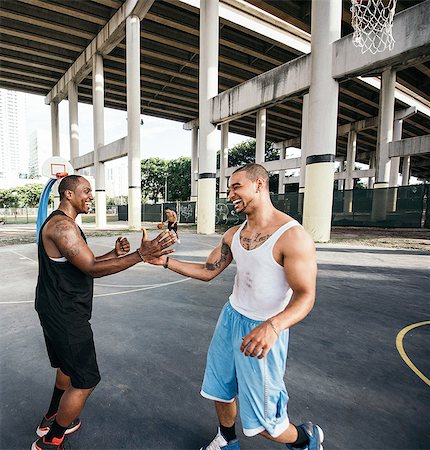 felicitaciones - Men on basketball court shaking hand smiling Foto de stock - Sin royalties Premium, Código: 614-08544702