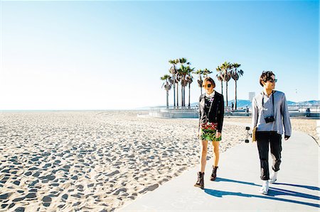 palm woman beach - Young couple walking along beach walkway Stock Photo - Premium Royalty-Free, Code: 614-08544724