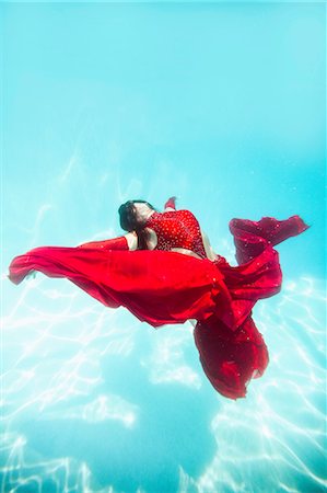 surreal - Woman wearing red dress,draped in red fabric, floating underwater Stock Photo - Premium Royalty-Free, Code: 614-08544798