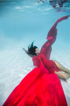 falling in water - Woman wearing red dress,draped in red fabric, floating underwater Stock Photo - Premium Royalty-Free, Code: 614-08544800