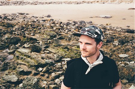 Man wearing baseball cap looking out from beach, Crystal Cove State Park, Laguna Beach, California, USA Stock Photo - Premium Royalty-Free, Code: 614-08544950